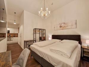 um quarto com uma cama grande e um lustre em Pension Mozart - Newly Renovated em Viena