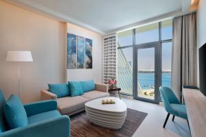 a living room with a couch and a table at NH Collection Dubai The Palm in Dubai