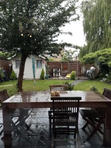 布魯日的住宿－Our Lily House, een gezellig familiehuis in rustige omgeving，院子里的一张木桌,四周摆放着椅子