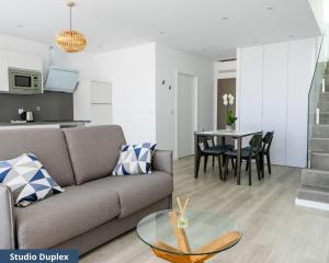 TRIADE Apartamentos في أفيرو: غرفة معيشة مع أريكة وطاولة
