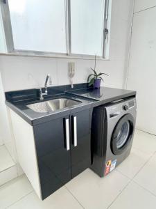 cocina con fregadero y lavadora en Ipanema Beach lovely apartment, en Río de Janeiro