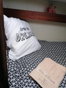 聖拉斐爾的住宿－Voilier de charme à quai，枕头坐在枕头旁边,带有标志的床上