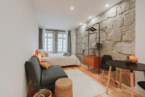 a bedroom with a bed and a stone wall at Casa Farrapos in Porto +29 photos