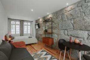 a bedroom with a stone wall and a bed at Casa Farrapos in Porto
