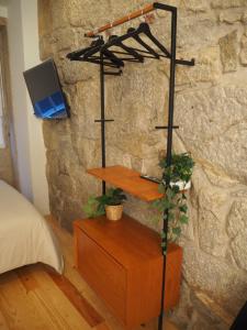 a bedroom with a tv on a wall with a shelf at Casa Farrapos in Porto