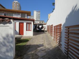 a street with a white fence and a building at Palm Hostal in Iquique