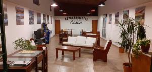uma sala de espera com um sofá branco e mesas em Departamentos Colón depto 8 em Carhué