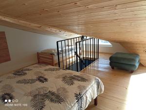- une chambre avec un lit et un escalier en bois dans l'établissement Snow Forest, à Bakuriani
