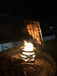 a fire pit with a grill with food in it at Olivos del Solar in Villa General Belgrano