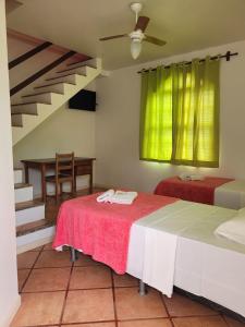 1 dormitorio con 2 camas y escalera en Pousada Villa Rosada en Santa Cruz Cabrália