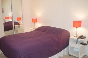 - une chambre avec un lit violet et un miroir dans l'établissement Green Park Exclusive Vacation, à Punta del Este