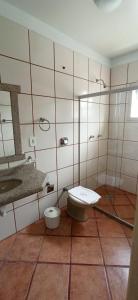 a bathroom with a toilet and a sink at Pousada Villa Rosada in Santa Cruz Cabrália