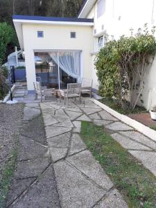 un patio con 2 sillas, una mesa y un perro en Studio Canapé convertible 2 pers avec jardin et parking clos, en Merlimont