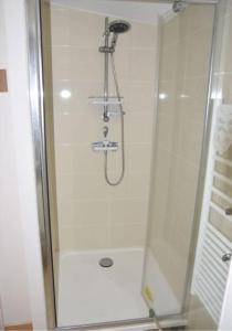 y baño con ducha y puerta de cristal. en Studio Canapé convertible 2 pers avec jardin et parking clos, en Merlimont