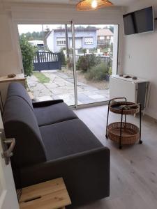 sala de estar con sofá y mesa en Studio Canapé convertible 2 pers avec jardin et parking clos, en Merlimont