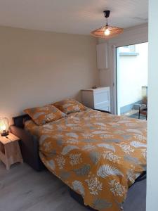 1 dormitorio con 1 cama y 1 mesa con lámpara en Studio Canapé convertible 2 pers avec jardin et parking clos, en Merlimont