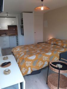 Dormitorio pequeño con cama, mesa y sidra de mesa en Studio Canapé convertible 2 pers avec jardin et parking clos, en Merlimont