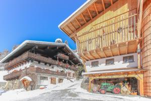 a large wooden building with a store in the snow at Remberghof in Viehhofen