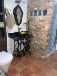 a bathroom with a sink and a brick wall at Nellie's Farmhouse in Carlingford +36 photos