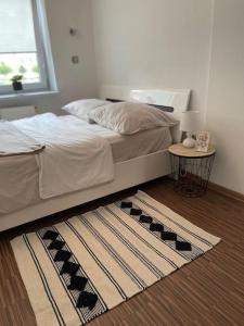 a bedroom with a bed and a rug on the floor at Urokliwy Apartament w Nowym Sączu in Nowy Sącz