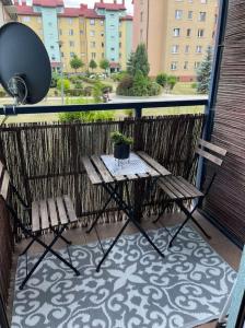 a table and two chairs on a balcony with a view at Urokliwy Apartament w Nowym Sączu in Nowy Sącz