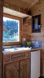 a kitchen with a sink and a window in a cabin at Cabane de l'aventurier in Saint-Nabord