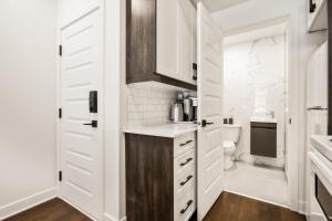 a white kitchen with a sink and a toilet at M11 Upscale Comfy Studio wAC in Perfect Location in Montréal