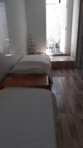 3 camas sentadas en una habitación con ventana en LA CASA DE LOS OLMITOS, en Punta del Este
