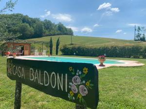 a sign in the grass next to a swimming pool at Casa Baldoni in Matelica