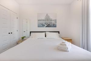 a white bedroom with a large white bed with towels on it at M11 Upscale Spacious 1BR wKingBed AC in Heart of PlateauMile-End in Montréal