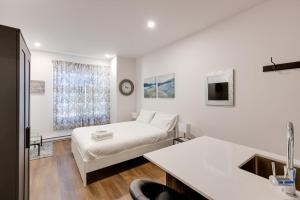 Habitación blanca con cama y lavamanos en M11 Modern Comfy Studio wAC in PlateauMile-End, en Montreal