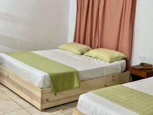 a bedroom with two twin beds and a red curtain at Cabañas CheRu 5 in Posadas