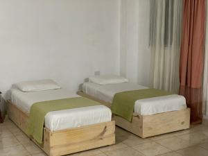 two twin beds in a room with white walls at Cabañas CheRu 5 in Posadas +9 photos