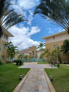 a walkway in front of a building with palm trees at Lindo Flat em resort silencioso e aconchegante in Brasília