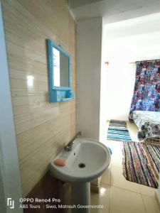 a bathroom with a sink and a bed and a mirror at A&S House in Siwa