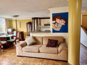 a living room with a couch and a painting on the wall at Quitumbe - Moderno y cómodo departamento in Quito