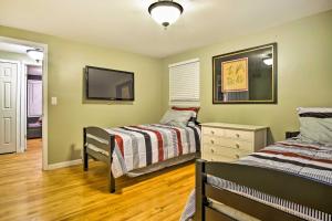 1 dormitorio con 2 camas y TV en la pared en Suburban Detroit Home with Porch, Yard and Fire Pit! en Southfield