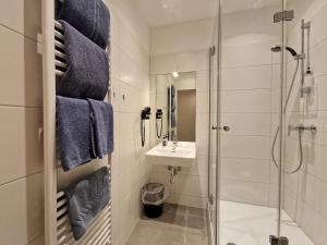 um banheiro com pia e chuveiro em Pension Mozart - Newly Renovated em Viena mais 31 fotografias