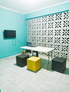 Habitación con mesa, 2 taburetes y TV. en Itapuã Corais Hostel e Pousada, en Salvador