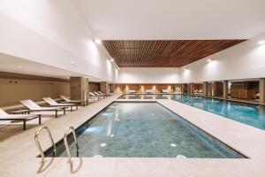 a large swimming pool in a hotel with chairs at Valtur Cristallo Ski Resort, Dependance Cristallino in Breuil-Cervinia