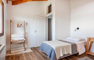 a white bedroom with a bed and a mirror at Jardín de Estepa in Dina Huapi