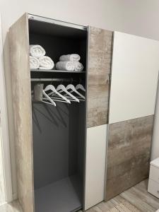 a closet with a door open with shoes and towels at PANORAMA Apartment Sombor in Sombor