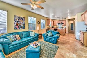 a living room with blue couches and a kitchen at Spacious Golf Home with Yard at Indian Palms Resort! in Indio