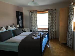 een slaapkamer met een bed en een groot raam bij Haus Anna Louise - Niedernsill in Niedernsill