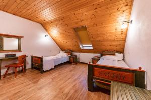 a bedroom with two beds and a wooden ceiling at Conacul Secuiesc-Székelykő Kúria in Colţeşti