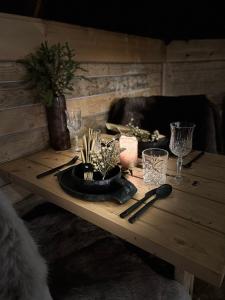 a wooden table with glasses and a plate on it at Skyfire Village Igloos in Rovaniemi +42 photos