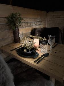 a wooden table with glasses and a plate on it at Skyfire Village Igloos in Rovaniemi