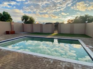 a swimming pool on the back of a house at Schuetzenhaus Guesthouse in Keetmanshoop