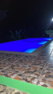 a swimming pool at night with blue lights at Kubo in Final Destination Resort in Bolinao