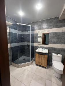 a bathroom with a shower and a toilet and a sink at Rooms Hotel Semey in Semey